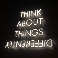 Image of neon that says 'think about things differently'